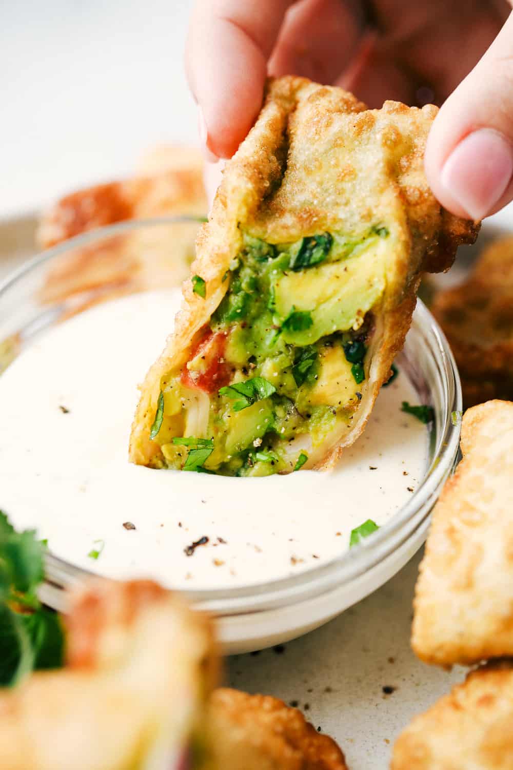Avocado Egg Rolls are crispy on the outside with an avocado mixtureย inside that is bursting with flavor! Once these hit the table theyย don't last long! Dipping avocado egg roll.
