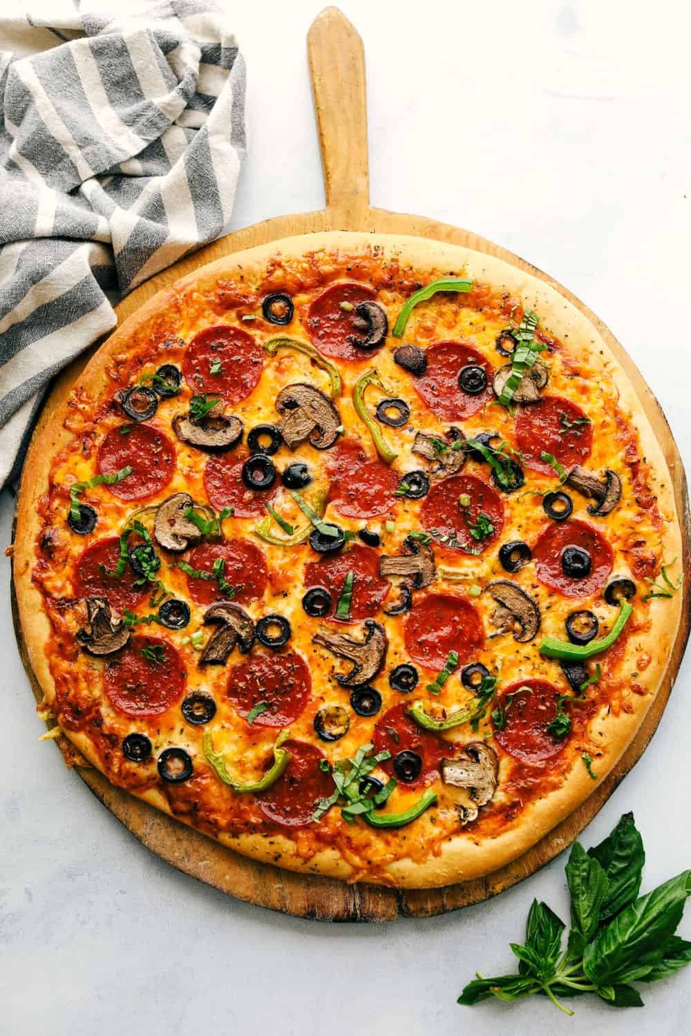 Easiest Homemade Pizza Ever! Foolproof, dough is ready in 20 minutes, best pizza ever and taken from my quick and easy dough recipe. Crispy crust with all your favorite toppings to make your pizza night a bonus! Finished pizza on a board.