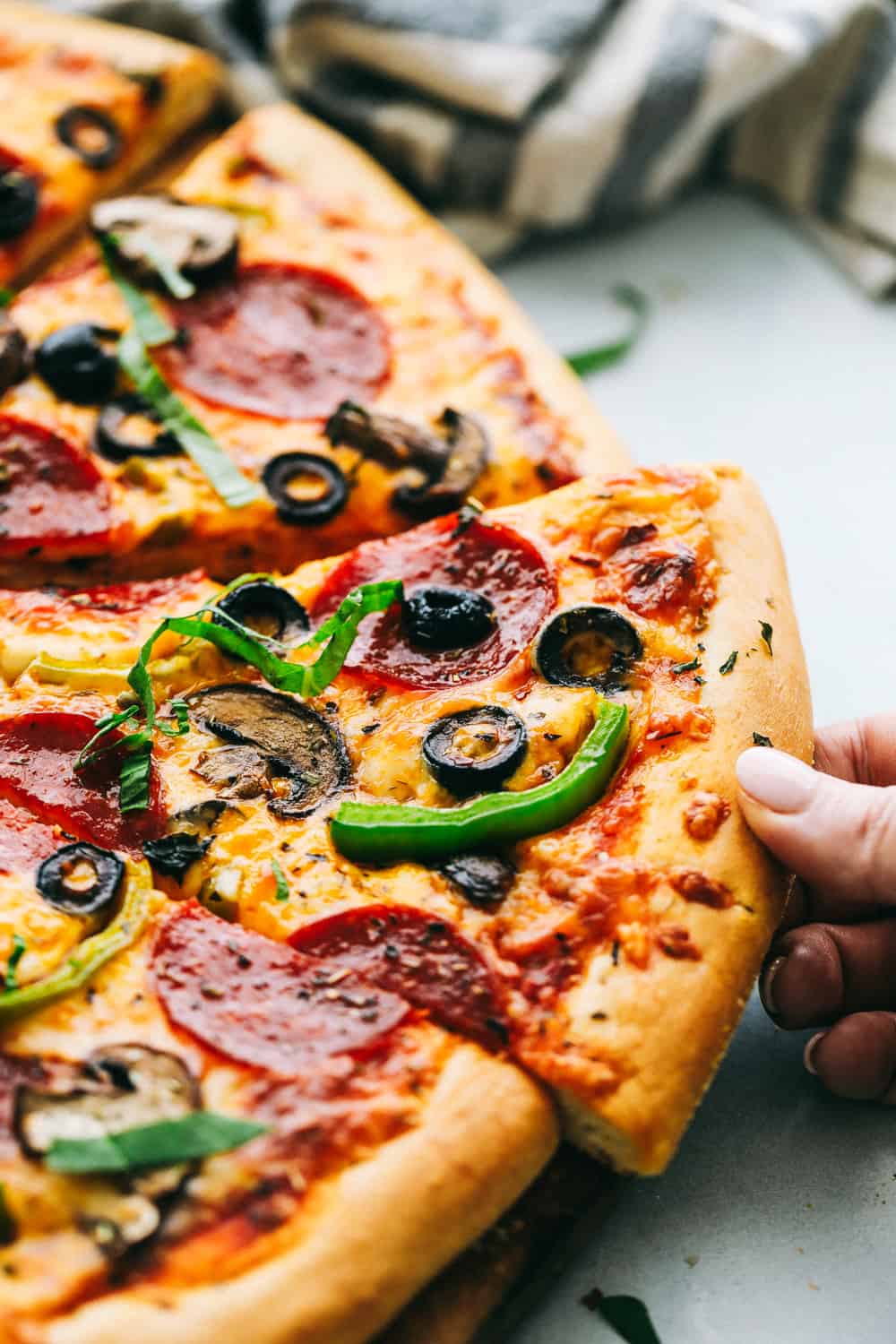 Easiest Homemade Pizza Ever! Foolproof, dough is ready in 20 minutes, best pizza ever and taken from my quick and easy dough recipe. Crispy crust with all your favorite toppings to make your pizza night a bonus! Close up on slice of pizza.