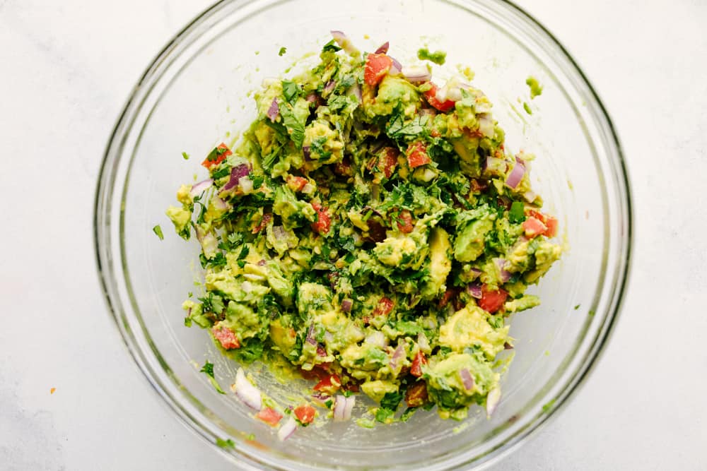 Avocado Egg Rolls are crispy on the outside with an avocado mixtureย inside that is bursting with flavor! Once these hit the table theyย don't last long! Avocado mixture in a bowl.