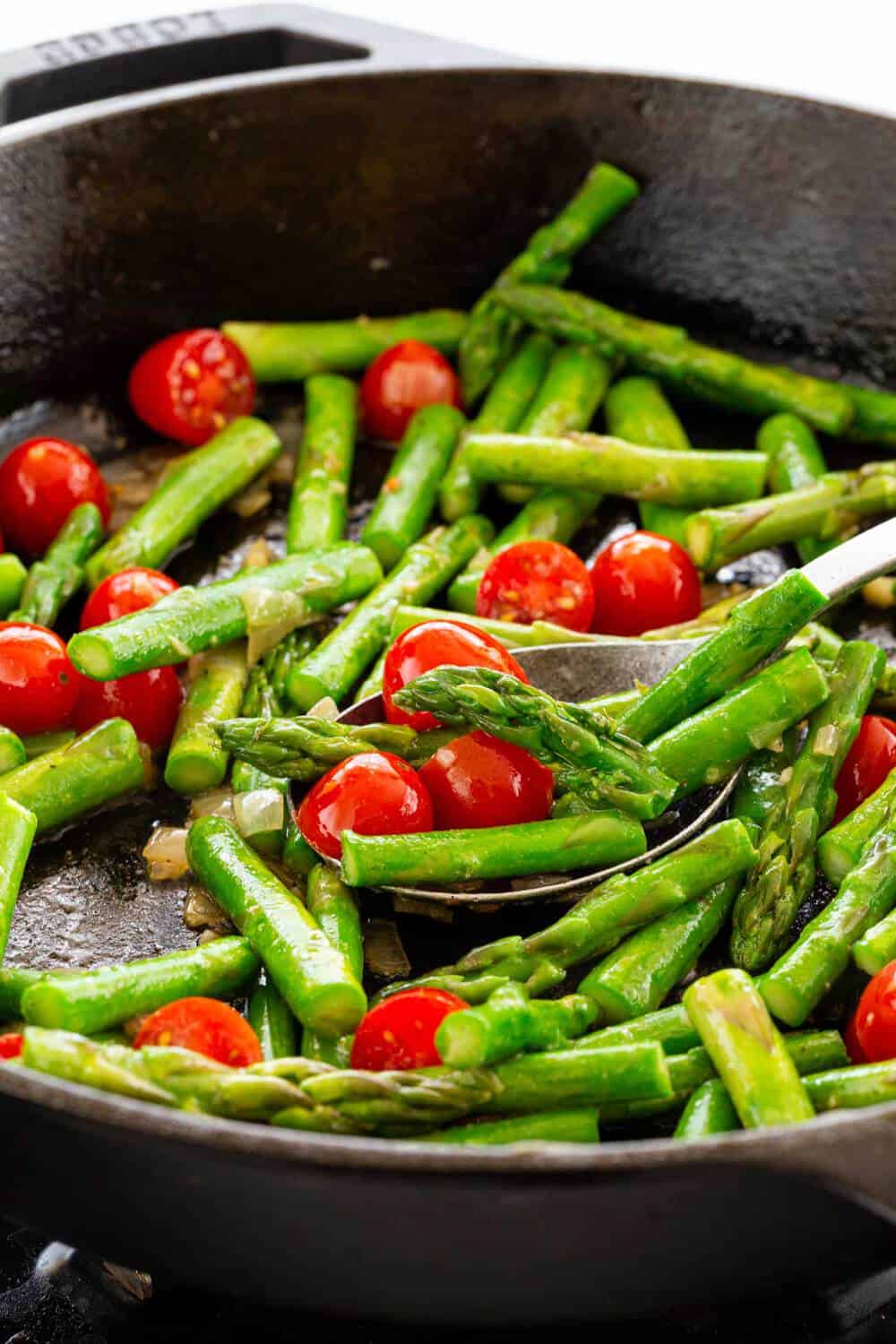 Lemon Garlic Shrimp and Asparagus Skillet is a quick and healthy one pan meal loaded with fresh citrus flavors. Tender jumbo shrimp are marinated in lemon, garlic, olive oil, and seasonings before they hit the pan. The seafood is sauteed with crisp asparagus and tomatoes for a wholesome dinner. asparagus cooking in a skillet