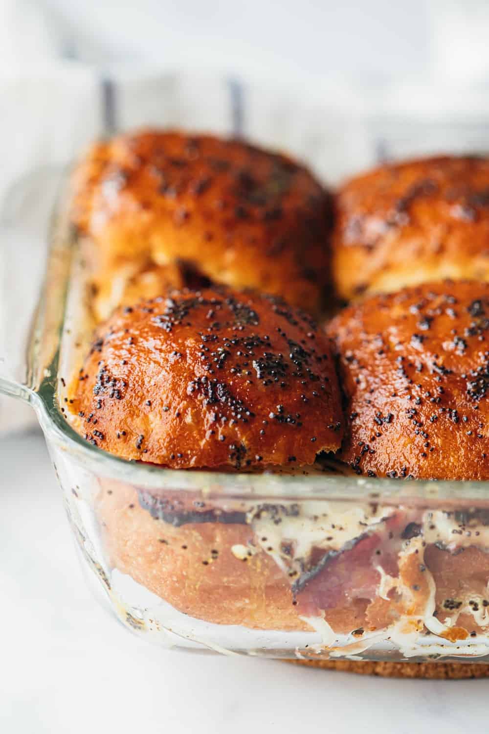 Hot Pastrami Sliders are the perfect tailgating food. They take all of ten minutes to prep and once they are baked, all you need to do is devour them! Closeup of Hot Pastrami Sliders