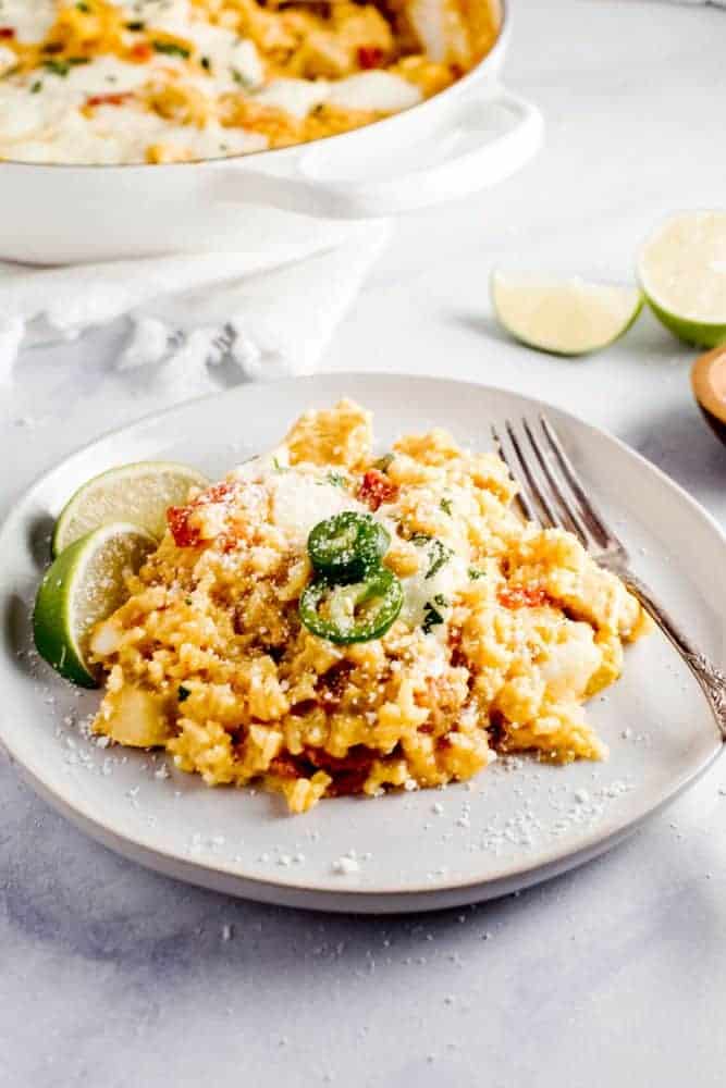 This Queso Chicken Skillet has the potential to become your families new favorite weeknight dinner. Creamy queso melted together with tender chicken, diced chilis and tomatoes, all mixed into tasty yellow rice create the perfect cheesy dinner. Queso chicken skillet on a plate.