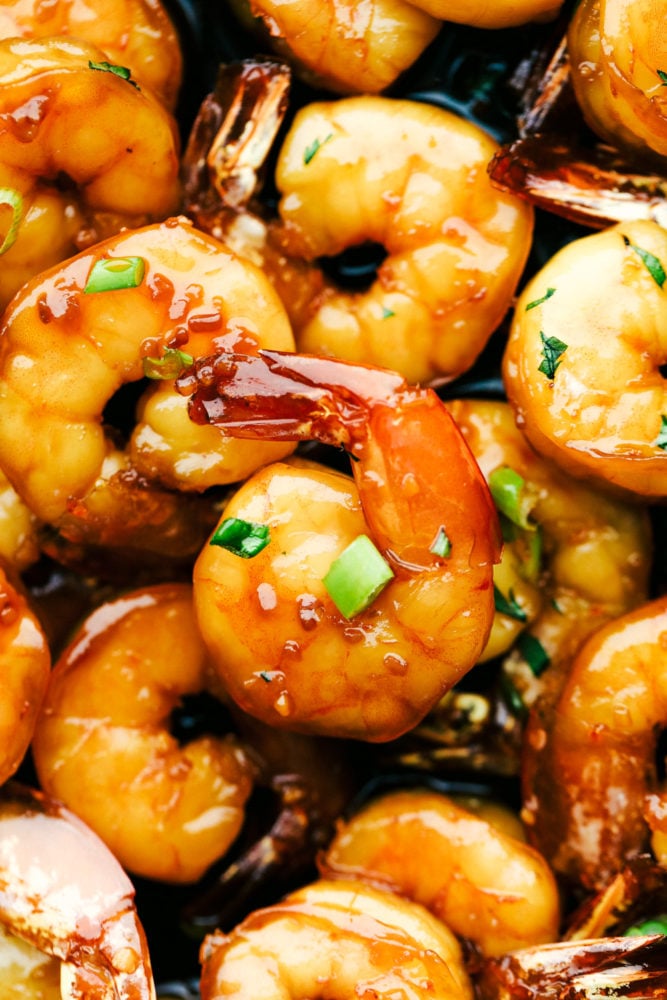 Sticky Honey Garlic Butter Shrimp are coated in the most amazing sticky honey garlic butter soy sauce. This is a quick 20 minute meal that you will make again and again! Sticky honey garlic butter shrimp up close with green onions garnished over top.