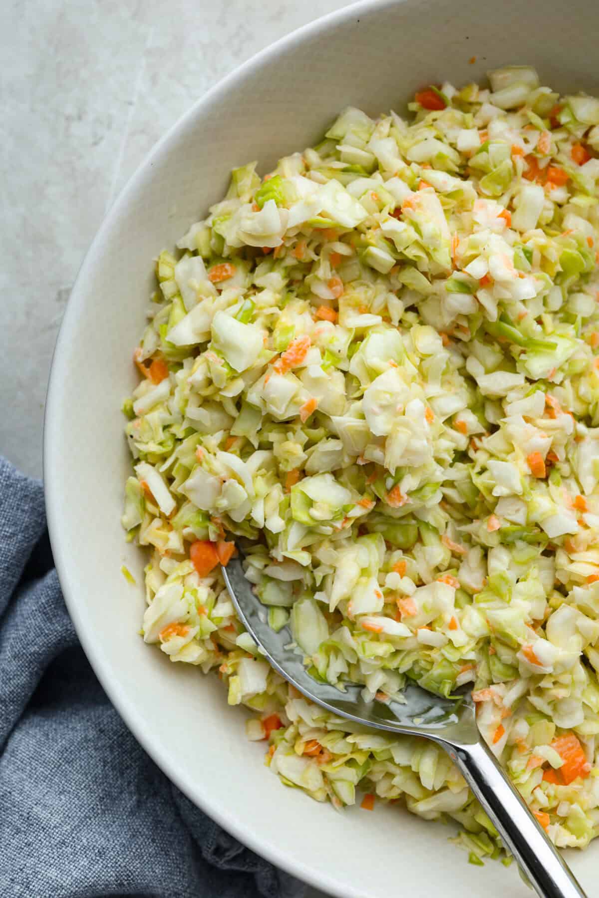 My Copycat KFC Coleslaw is so spot-on, youโll think itโs the real deal! Crunchy, creamy, tangy, and perfect for any BBQ, everyone will want the recipe! Close up shot of copycat KFC coleslaw in a serving bowl.