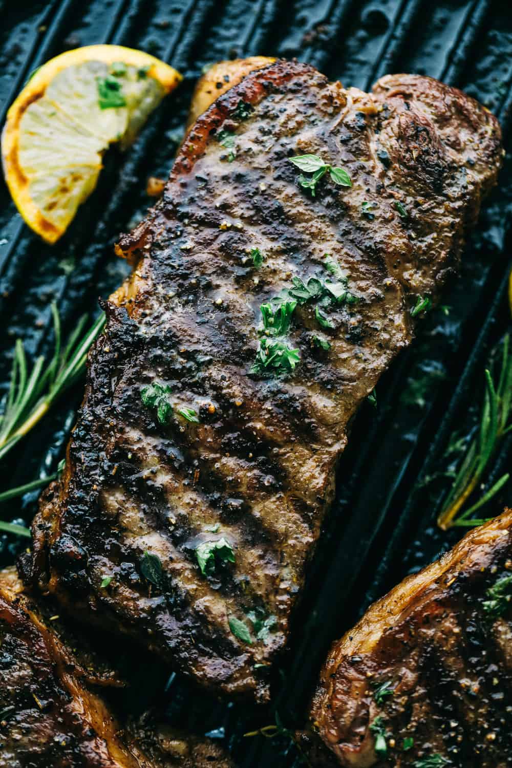 Perfectly Juicy Grilled Steak gets marinaded in the best flavor and grilled to juicy perfection! Learn all of the tips and tricks to grill the BEST steak every single time! Finished steak on a grill pan.