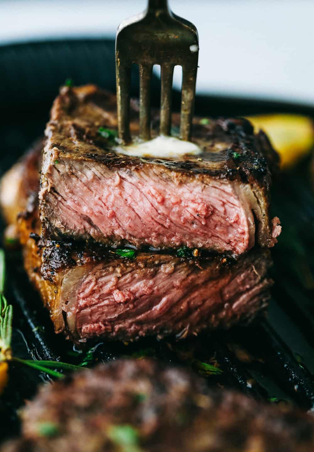 Perfectly Juicy Grilled Steak gets marinaded in the best flavor and grilled to juicy perfection! Learn all of the tips and tricks to grill the BEST steak every single time! Taking a bite of steak with a fork.