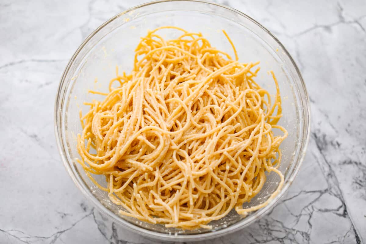 Baked spaghetti is the ultimate comfort food, with noodles that soak up all of the rich sauce as they finish cooking, making every bite extra flavorful. Plus, itโs a lifesaver on busy days. You can prep it ahead, pop it in the oven, and still have a cozy, home-cooked meal without the stress! Overhead shot of noodles mixed with the egg, butter and cheese mixture.