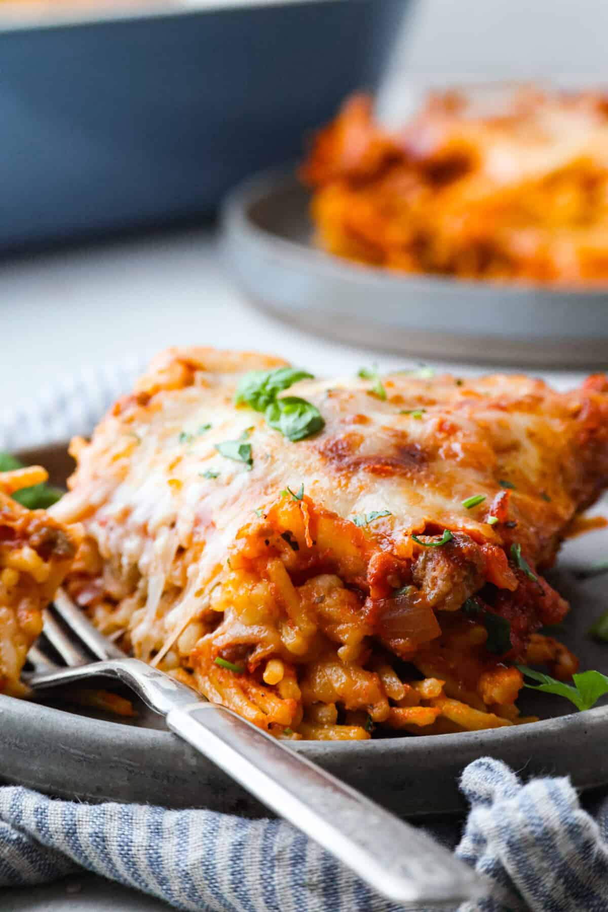 Baked spaghetti is the ultimate comfort food, with noodles that soak up all of the rich sauce as they finish cooking, making every bite extra flavorful. Plus, itโs a lifesaver on busy days. You can prep it ahead, pop it in the oven, and still have a cozy, home-cooked meal without the stress! Close up shot of plated baked spaghetti.