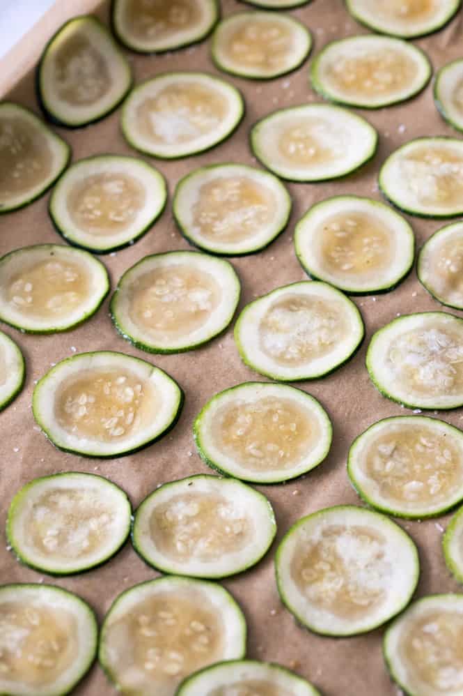 Need something to do with all of that fresh zucchini in your garden? I highly recommend you try this simple recipe for homemadeย Zucchini Chips! Simple to make and baked in the oven, these are a light, fun snack! A picture of zucchini chips baking.