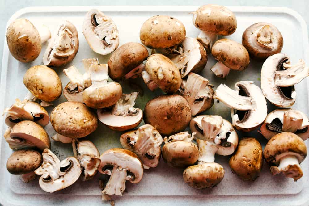 Buttery Herb Sautéed Mushrooms are tender mushrooms coated in a seasoned mixture that are sautéed until they are tender in a buttery herb sauce. The perfect side dish to any meal! mushrooms being cleaned and prepped for sautéing