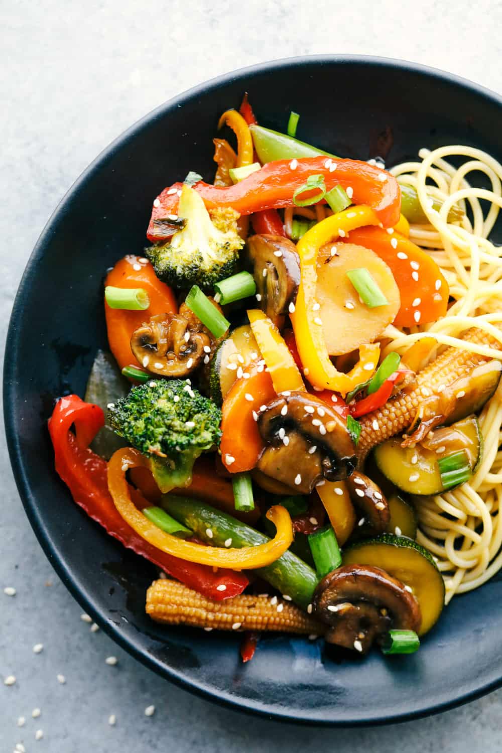 You all love this vegetable stir fry, and I donโt blame you. Itโs fast, flexible, and that sauce? So addicting! Toss in whatever veggies you have and dinnerโs done. Plated vegetable stir fry with noodles.