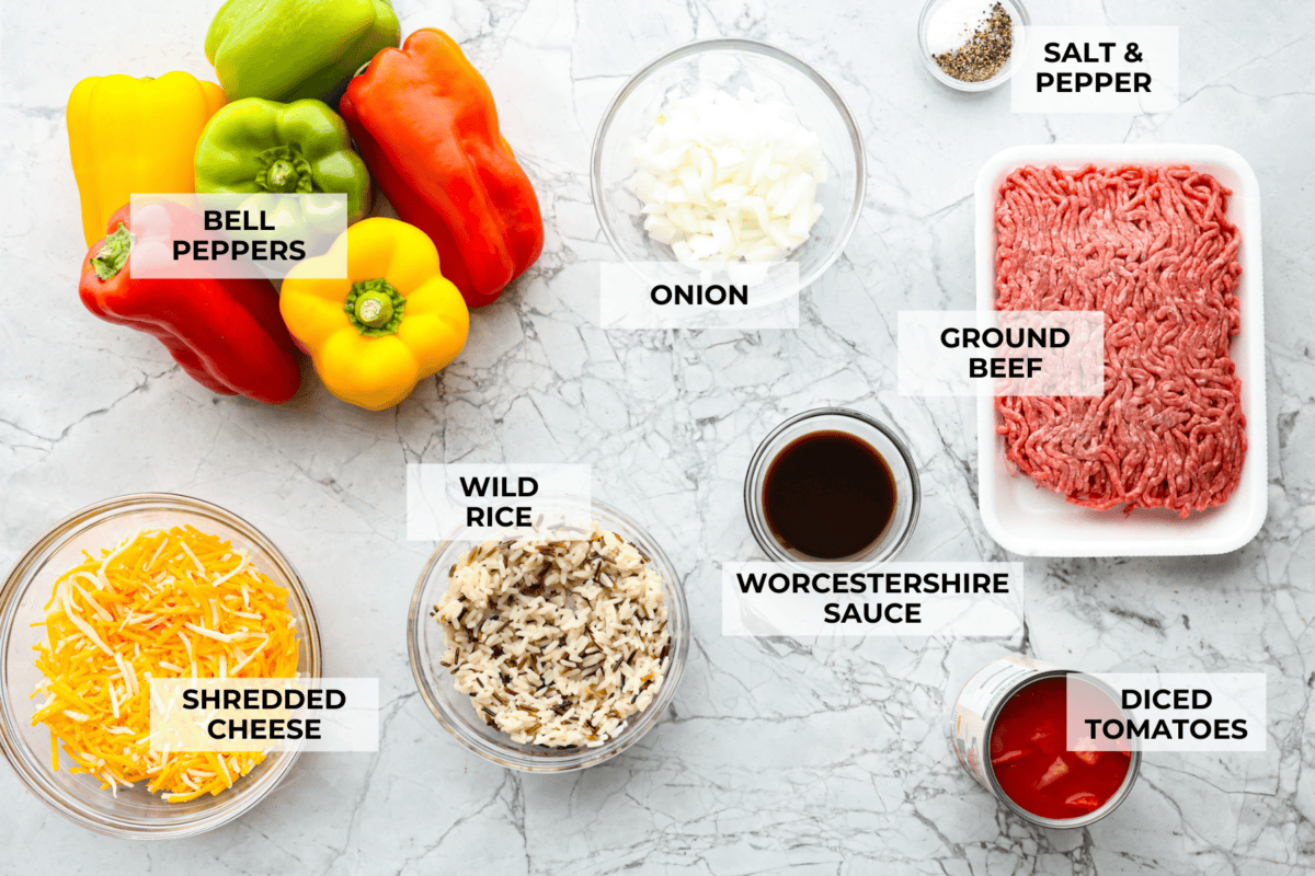 Slow cooker stuffed bell peppers are packed with ground beef, wild rice, diced tomatoes, soft black beans, and melty cheese. They cook to perfection in the slow cooker and make a healthy, delicious dinner your whole family will love! Overhead shot of labeled ingredients.