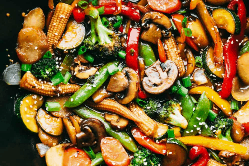 You all love this vegetable stir fry, and I donโt blame you. Itโs fast, flexible, and that sauce? So addicting! Toss in whatever veggies you have and dinnerโs done. Cooked vegetable stir fry garnished with sesame seeds and green onions.