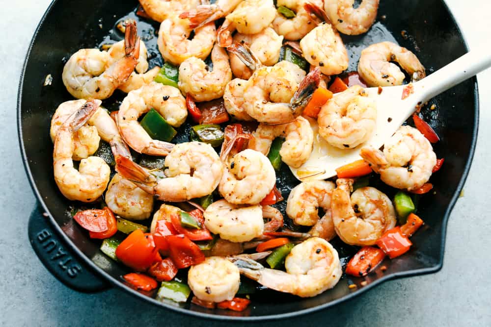 Awesome Kung Pao Shrimp is filled full of flavor with large shrimp, tender bell peppers, nutty peanuts cooked together with a sweet and spicy sauce. Ready in under 20 minutes! shrimp and bell peppers sautéing together