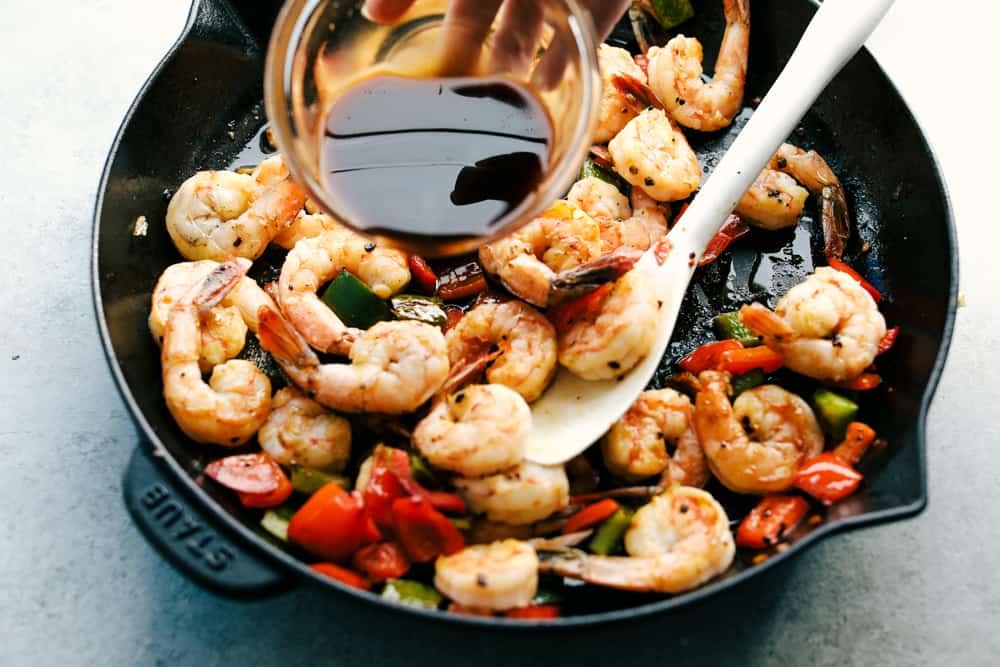 Awesome Kung Pao Shrimp is filled full of flavor with large shrimp, tender bell peppers, nutty peanuts cooked together with a sweet and spicy sauce. Ready in under 20 minutes! sauce poured over shrimp and bell peppers