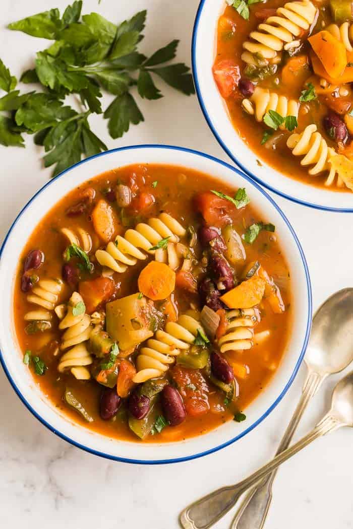 This easy Minestrone Soup recipe is loaded with vegetables, beans and pasta and flavored with Italian herbs for an easy weeknight dinner the whole family will love! #soup #recipe #minestrone minestrone soup bowls overhead