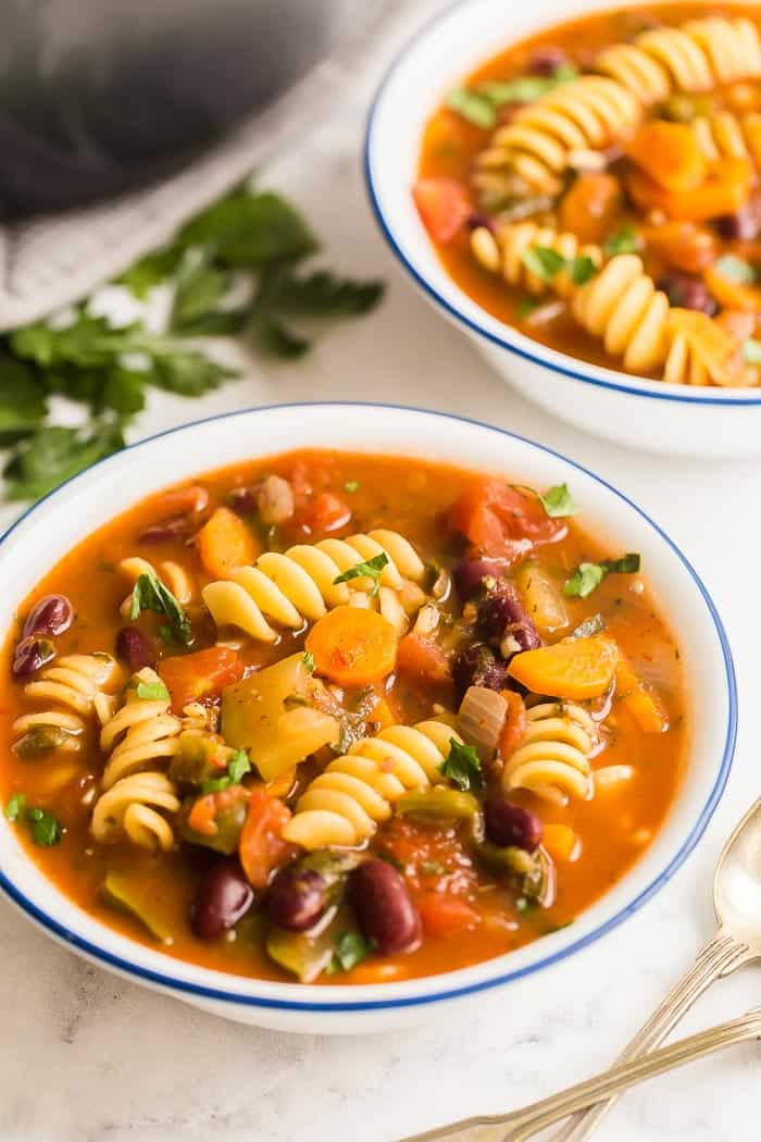 This easy Minestrone Soup recipe is loaded with vegetables, beans and pasta and flavored with Italian herbs for an easy weeknight dinner the whole family will love! #soup #recipe #minestrone minestrone soup in white bowl