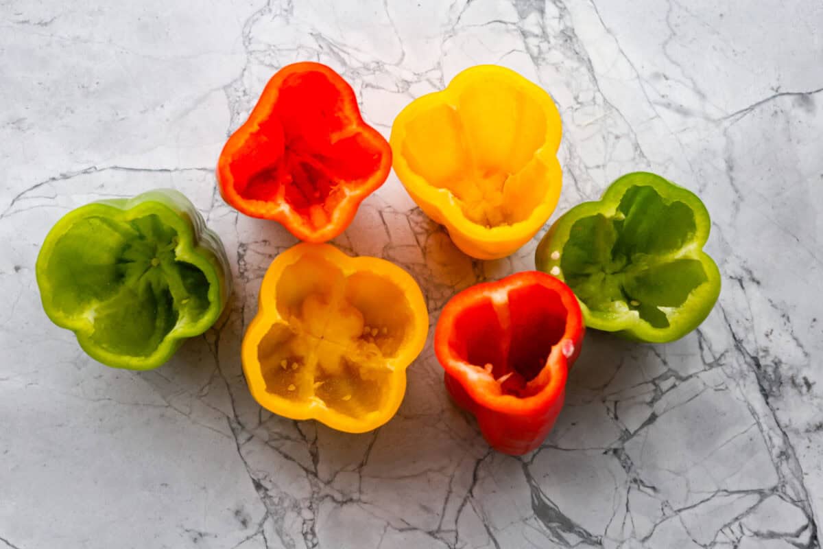 Slow cooker stuffed bell peppers are packed with ground beef, wild rice, diced tomatoes, soft black beans, and melty cheese. They cook to perfection in the slow cooker and make a healthy, delicious dinner your whole family will love! Overhead shot of prepped peppers.