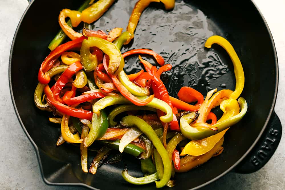 Amazing Steak Fajitas have tender marinated, juicy steak with colorful bell peppers wrapped in a soft shell tortilla topped with all your favorites. A complete dinner in 45 minutes! bell peppers sautéing in a skillet