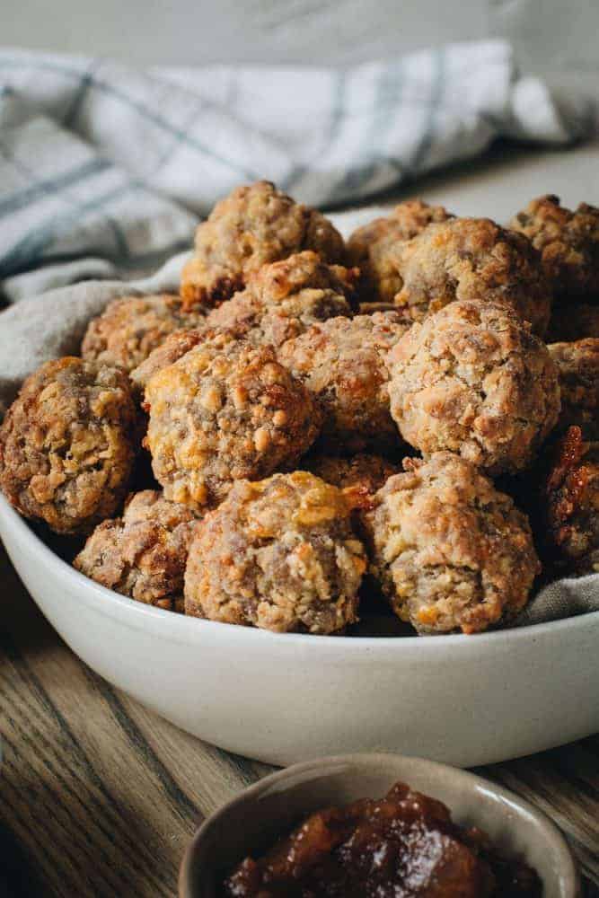 Perfect party appetizers make the holidays sweeter and full of savory memories. These Easy Sausage Balls are a southern serving staple with simple ingredients or sausage, cheddar cheese, Bisquick, and olive oil. Easy Sausage Balls