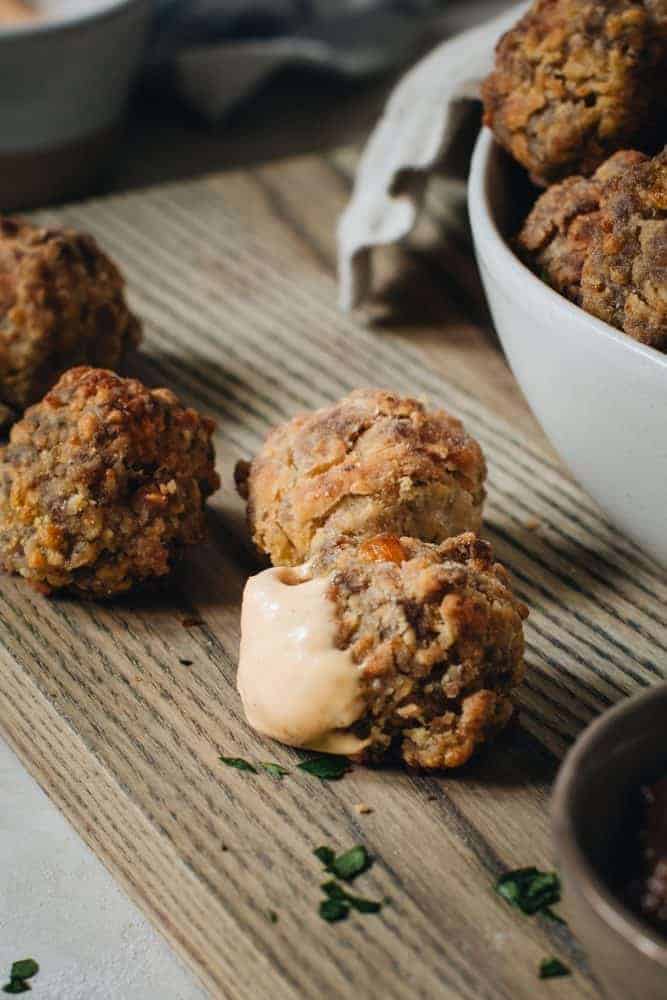 Perfect party appetizers make the holidays sweeter and full of savory memories. These Easy Sausage Balls are a southern serving staple with simple ingredients or sausage, cheddar cheese, Bisquick, and olive oil. Sausage Balls with Dip