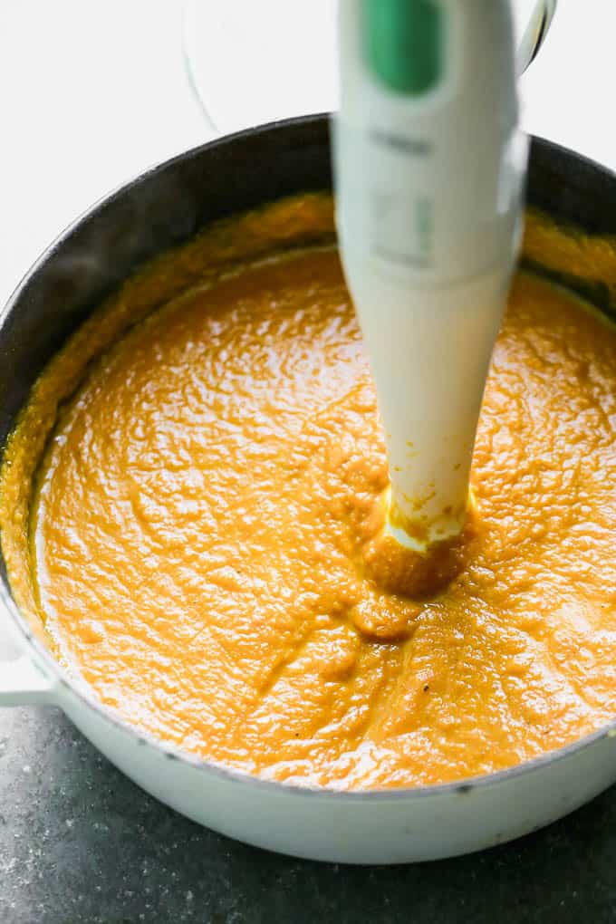 This Creamy Pumpkin Soup is packed with pumpkin flavor, a touch of sweetness, and velvety smooth. It's the perfect cozy fall soup, and it only takes 30 minutes to throw together! Blending the pumpkin soup in a pot