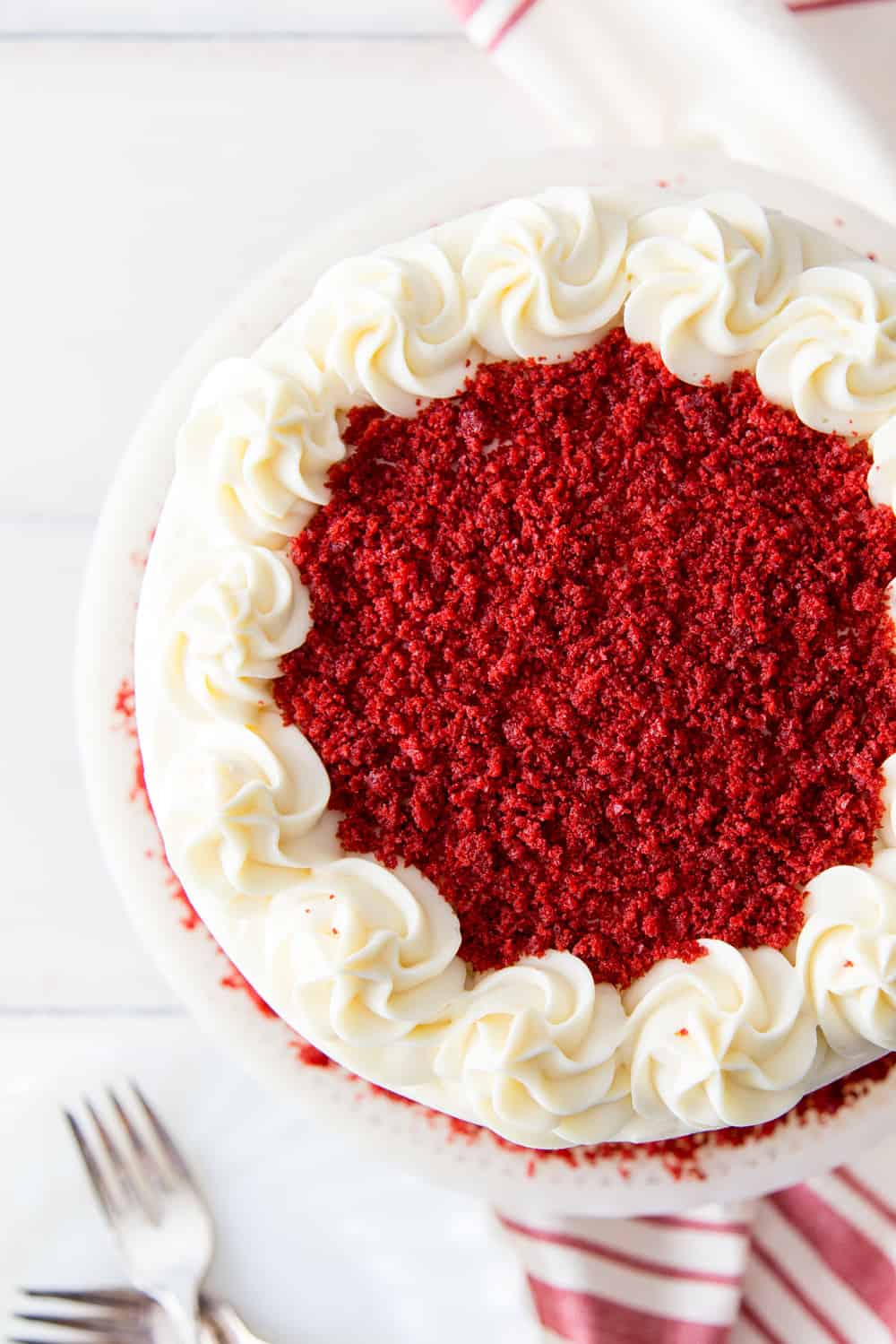 Red Velvet Cake Recipe is a classic must-have in your dessert arsenal. The super moist and slightly chocolaty cake, covered in a tangy cream cheese frosting, is the perfect way to end a great meal. The top of a red velvet cake