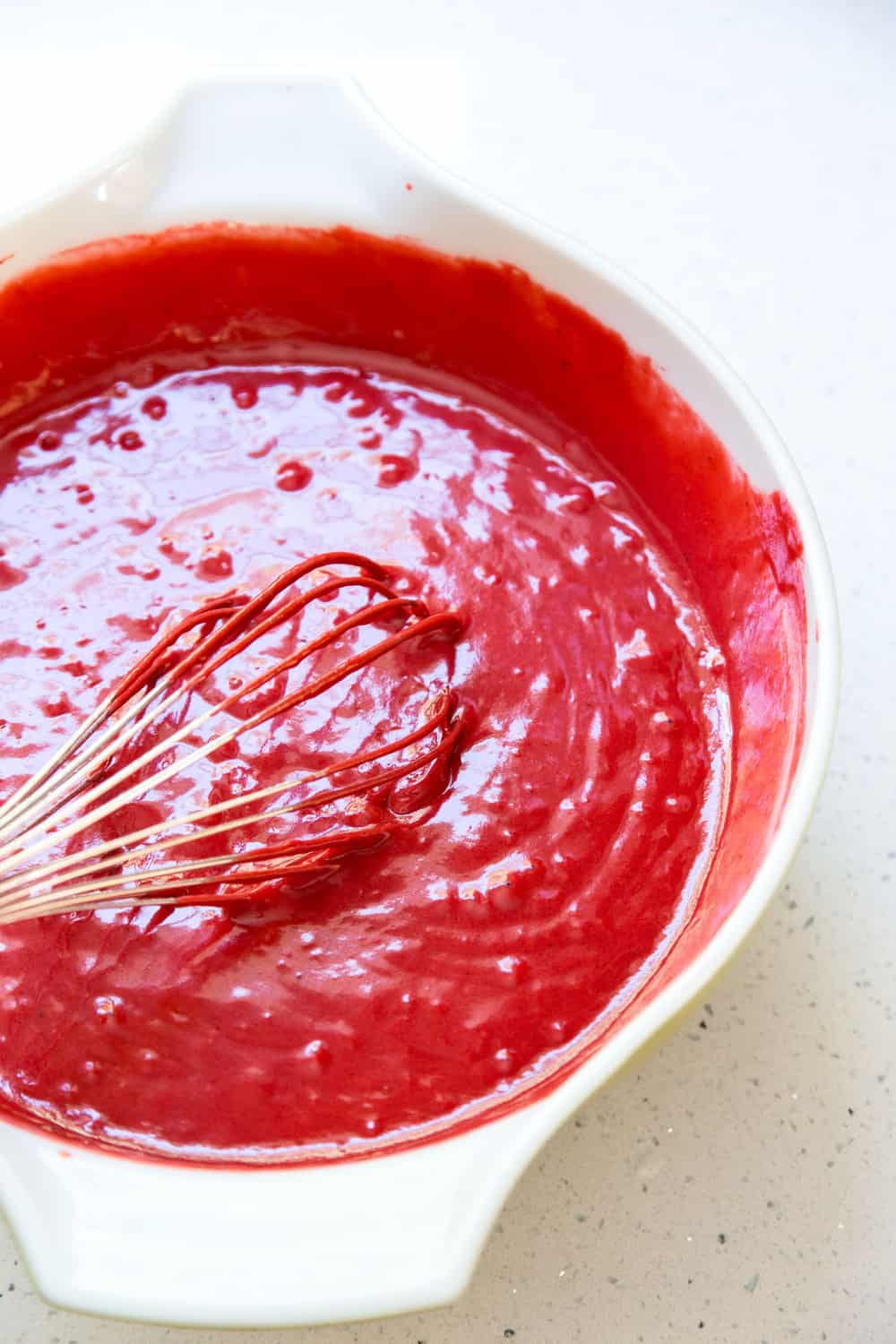 Red Velvet Cake Recipe is a classic must-have in your dessert arsenal. The super moist and slightly chocolaty cake, covered in a tangy cream cheese frosting, is the perfect way to end a great meal. Red velvet cake batter in a mixing bowl