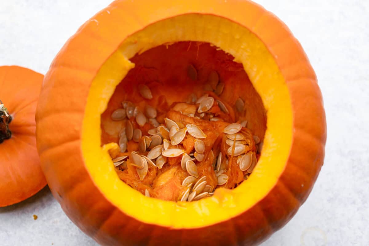 Crazy Good Roasted Pumpkin Seeds are a healthy and delicious snack you can enjoy while carving pumpkins this Halloween season. They are packed with essential vitamins and antioxidants that help you sleep better, boost your immune system, and promote heart health. Overhead shot of carved out pumpkin.