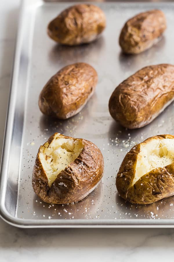 This Baked Potato Recipe is easy to make with just Russet potatoes and seasonings. Top it any way you like for the perfect side dish at any meal! baked potatoes sheet pan
