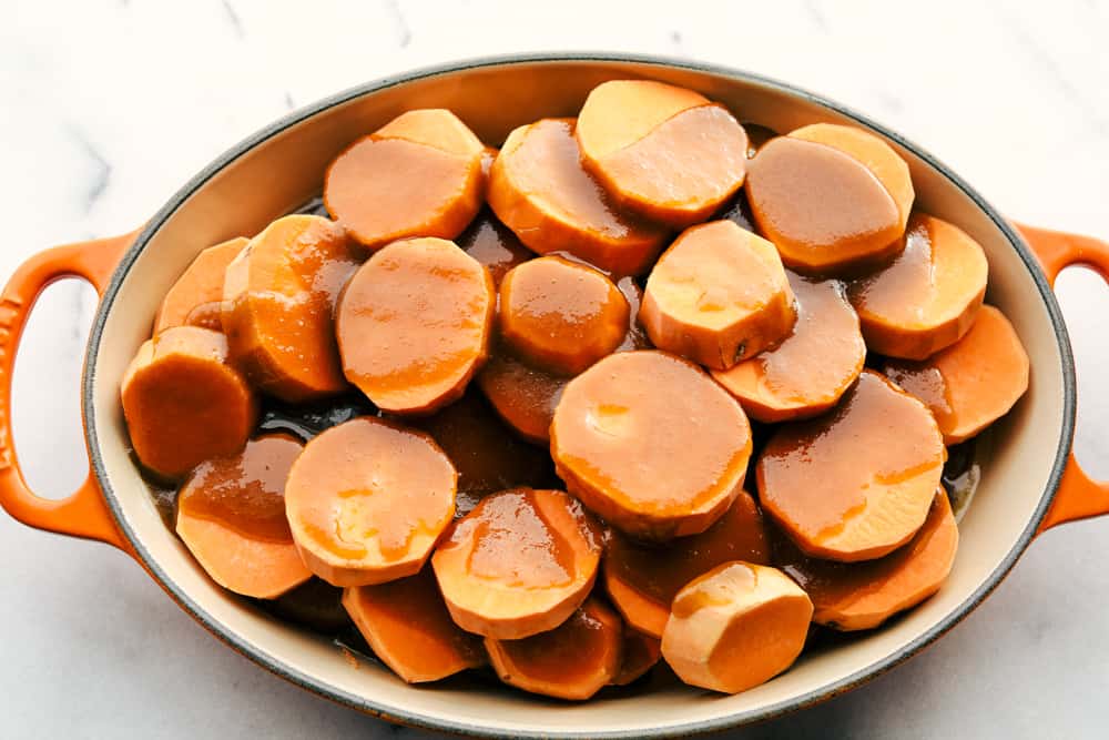 Candied Sweet Potatoes are just that, sweet and tender, juicy, bright orange sweet potatoes that will warm your home and melt in your mouth! Only 3 ingredients is all you need! sweet potatoes in pot with candied sauce over top