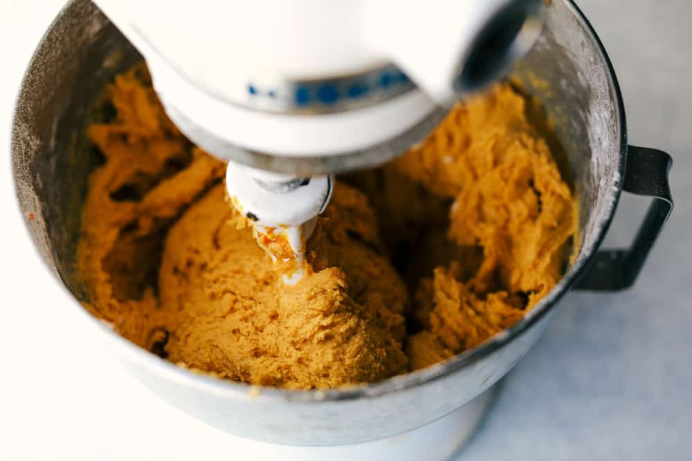 Soft and Puffy Pumpkin Snickerdoodles are made with real pumpkin, fall seasonal spices mixed together and rolled with pumpkin pie spice and aย touch of sugar to add that extra sweetness and fallย flavor! This are a MUST make this fall season! pumpkin snickerdoodle mixture in a kitchen aid