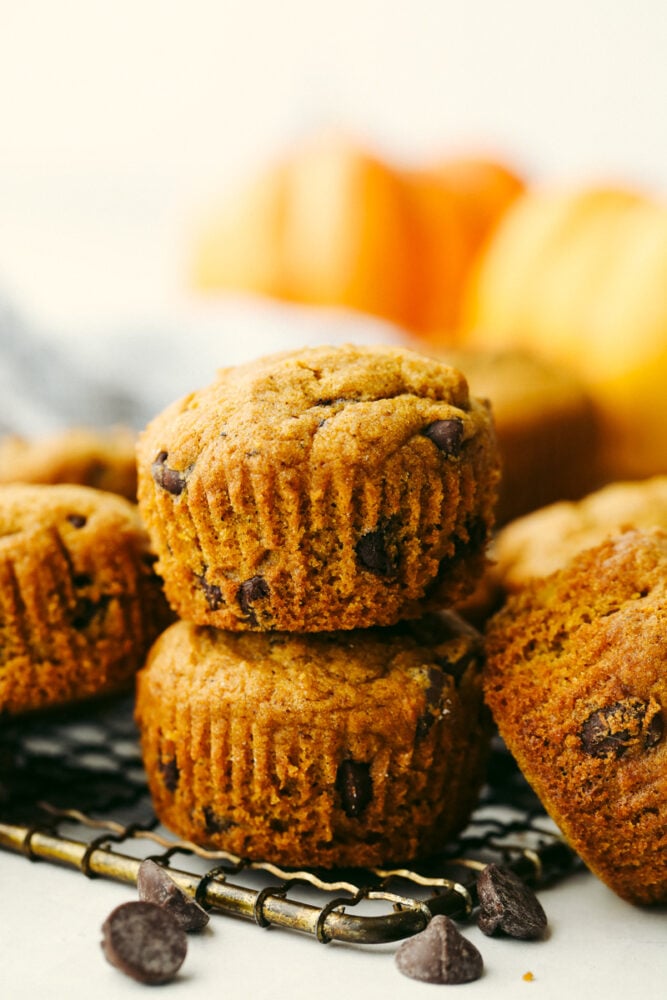 Chocolate Chip Pumpkin Muffins are soft fluffy muffins that are studded with semisweet chocolate and topped off with a sprinkling of sugar! Pumpkin chocolate chip muffins stacked on top of each other.