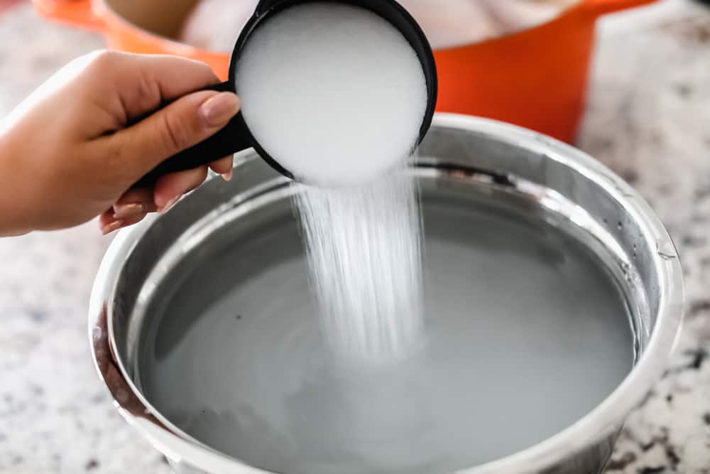 Turkey Brine creates aย tender, moist and juicy turkey withย sweet citrusy flavoring and a hint of spice all submerged in a water bath for your turkey to soak from the inside-out. Make your turkey irresistible this holiday season! Adding salt to a bowl of water.