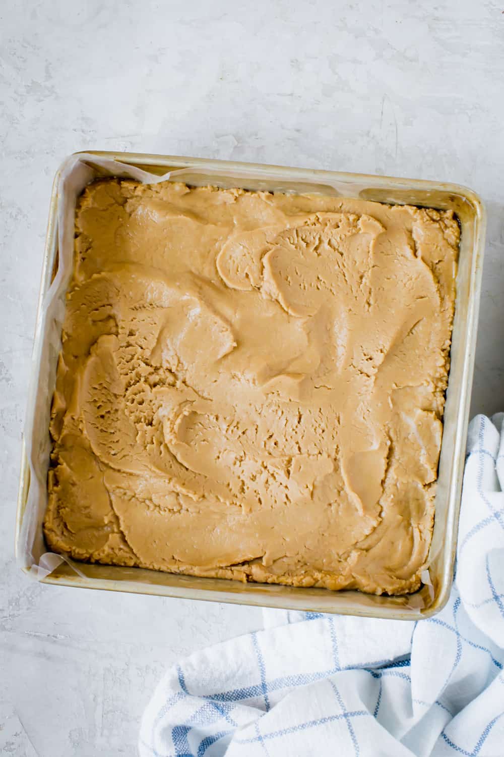 Creamy and smooth with a sweet peanut butter taste, this fudge is made with powdered sugar and butter for a deliciously soft and crumbly treat. Peanut Butter Fudge is a decadent dessert that is extremely easy to make. No candy thermometers and only five ingredients. peanut butter fudge smoothed into pan
