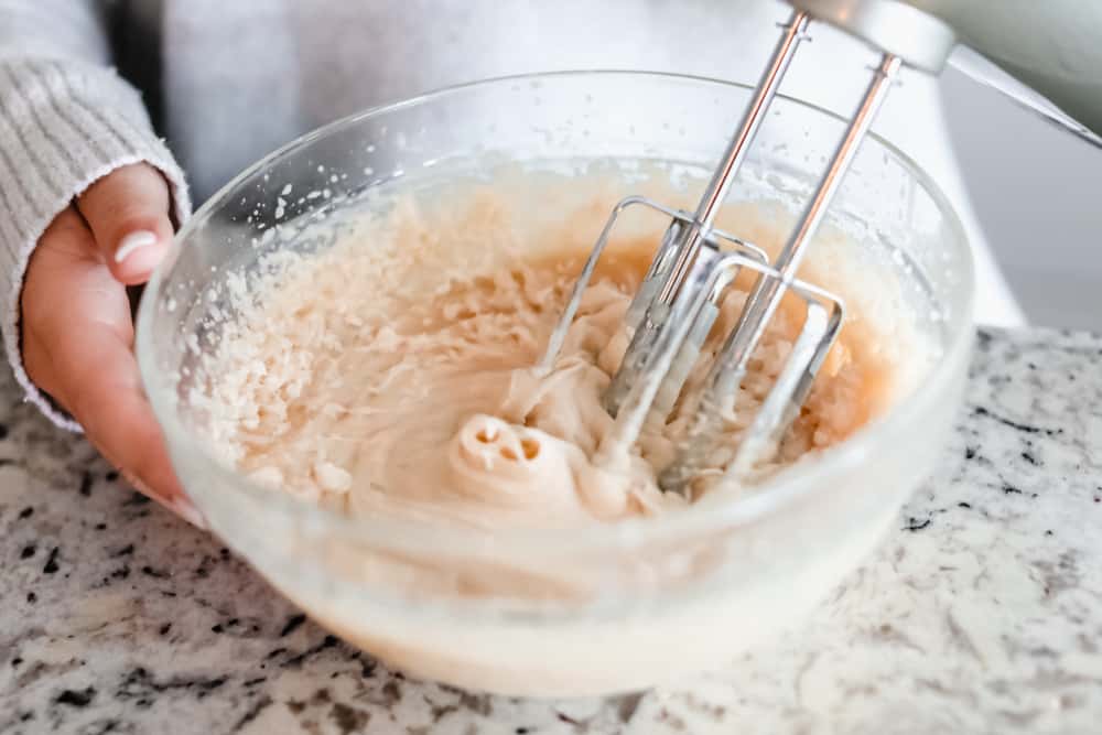 Maple Plant Butter (Three Ways!) is a smooth, creamy plant based butter that spreads perfectly over a piece of fresh bread and melts into all the cracks! You won't be able to live without it! A hand mixer whipping the maple plant butter