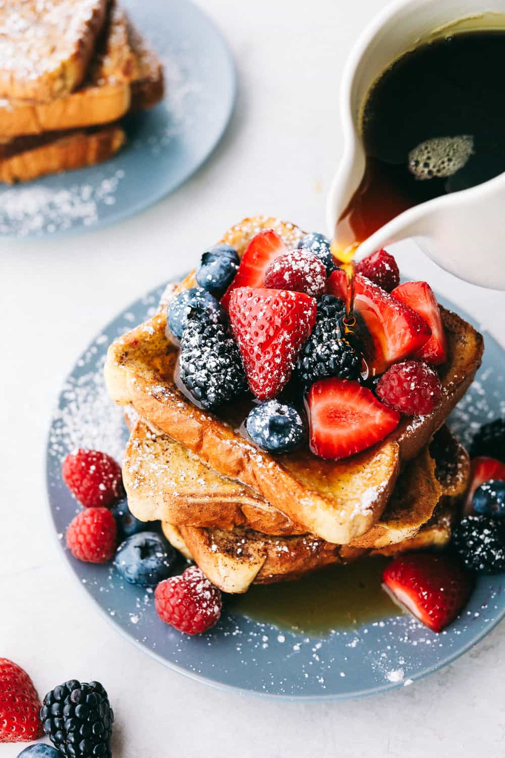 French Toastย is a sliced thick, chunky bread dipped in aย creamy egg, milkย and cinnamon mixture with a secret ingredient that will take thisย French toast over the top! A little slice of heaven on your plate!ย French toast covered with berries, sprinkled with powdered sugar and syrup.