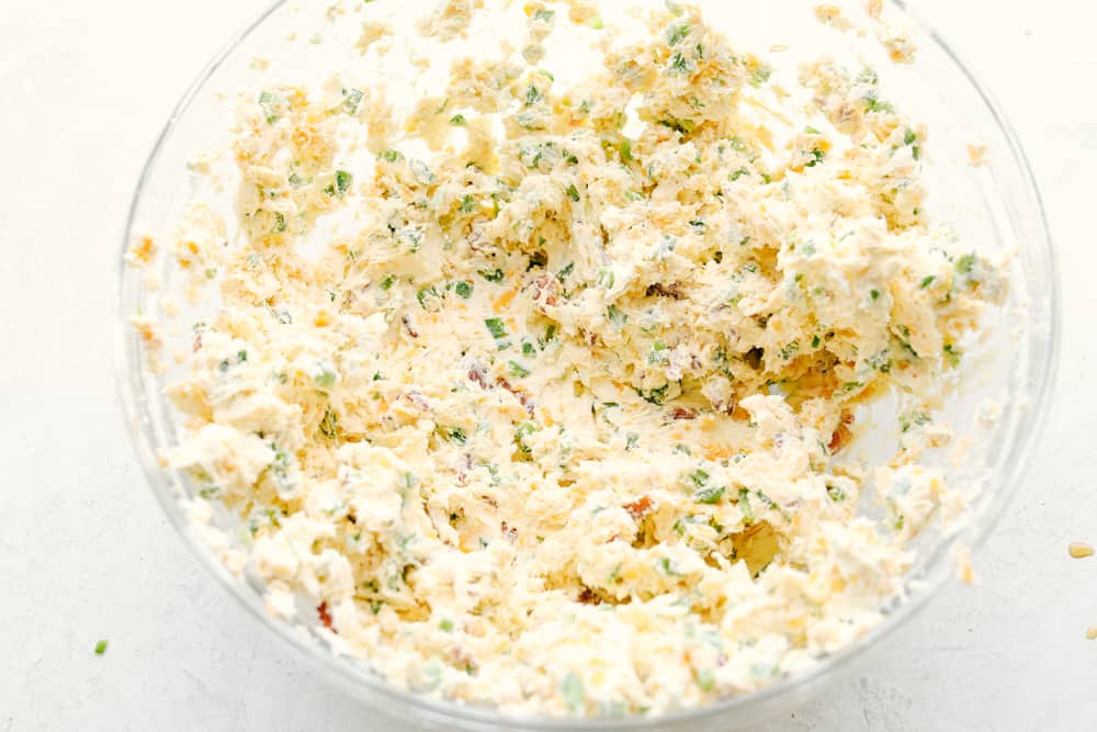 This jalapeno bacon cheese ball is perfectly creamy, rolled in crunchy bacon, and topped off with green onions and salty pecans. It's the perfect holiday appetizer and filled with SO much flavor! Stirring up the ingredients into a luscious mixture.