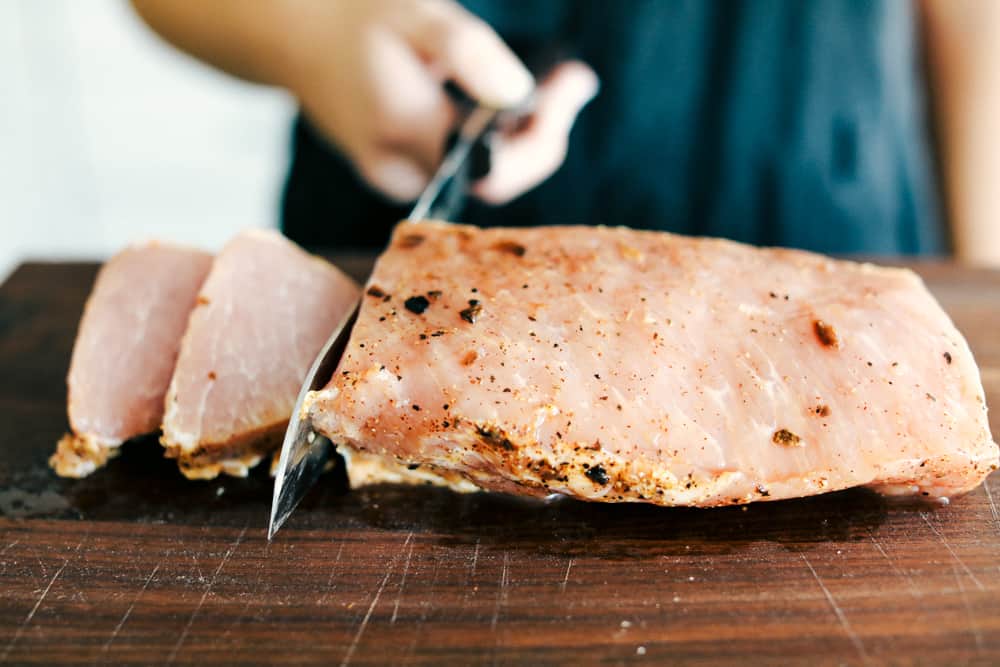 Skillet Pork Chops with Maple Dijon Vegetables is marinated Smithfield Steakhouse Mushroom Flavored Pork cut into pieces andย sautรฉed with tender vegetables covered with aย golden mapleย glaze. All under 30 minutes! pork cut up into slices on a cutting board