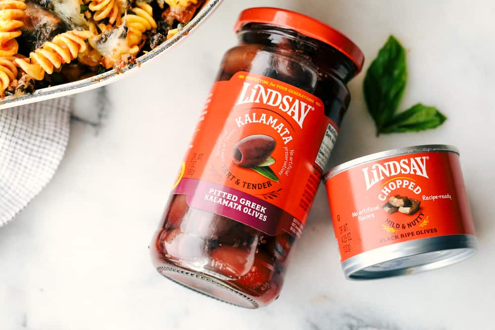 This Turkey Mediterranean Casserole features artichokes, fusilli pasta, sun dried tomatoes and Lindsay® Kalamata Olives baked in a red tomato sauce and topped with Lindsay® Chopped Black Olives. Simple, delicious ingredients in 30 minutes! Lindsay Olives in a jar, laying down.