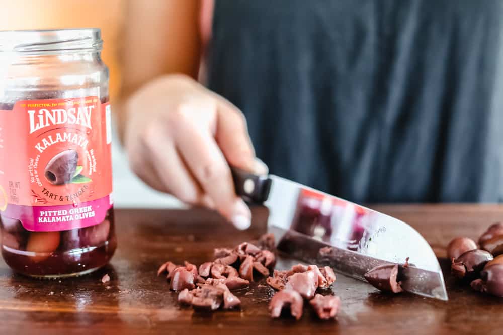 This Turkey Mediterranean Casserole features artichokes, fusilli pasta, sun dried tomatoes and Lindsay® Kalamata Olives baked in a red tomato sauce and topped with Lindsay® Chopped Black Olives. Simple, delicious ingredients in 30 minutes! Cutting Lindsay Olives up with a knife