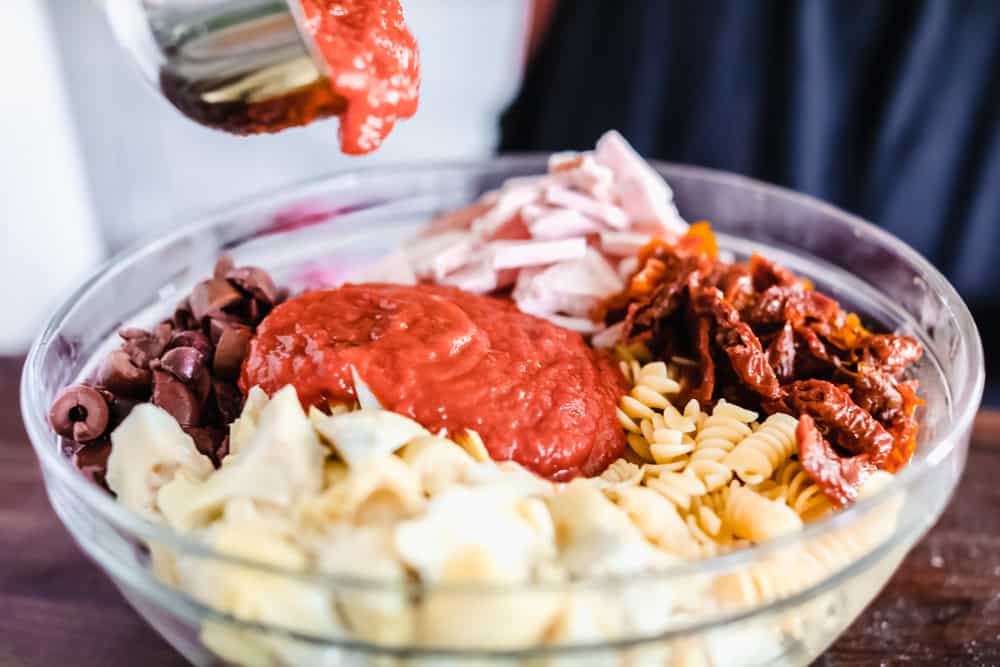 This Turkey Mediterranean Casserole features artichokes, fusilli pasta, sun dried tomatoes and Lindsay® Kalamata Olives baked in a red tomato sauce and topped with Lindsay® Chopped Black Olives. Simple, delicious ingredients in 30 minutes! Turkey Mediterranean casserole in a bowl with all the ingredients separated.