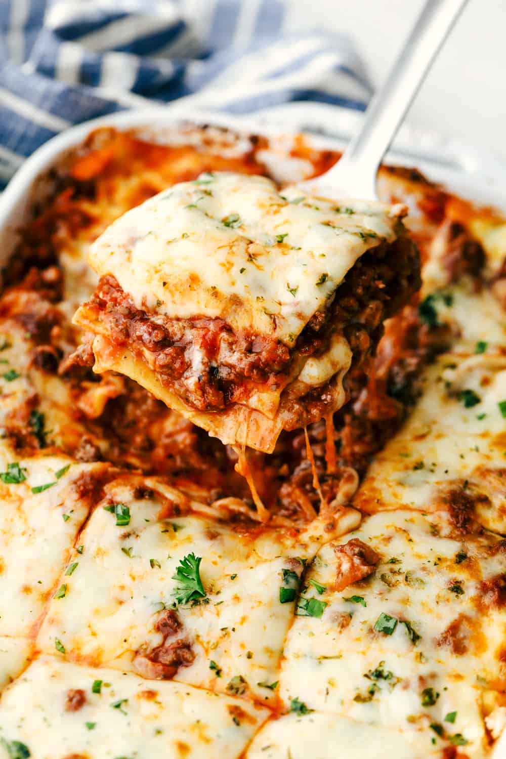 The Best Classic Lasagna Ever has layers of sautéed ground beef and Italian sausage that are cooked together, sweet tomato sauce, Italian seasoning all layered with lasagna noodles then covered in ricotta cheese and a parmesan mixture all sprinkled with mozzarella cheese for a mouthwatering baked Italian dinner. Layers of deliciousness! Baked lasagna in a pan