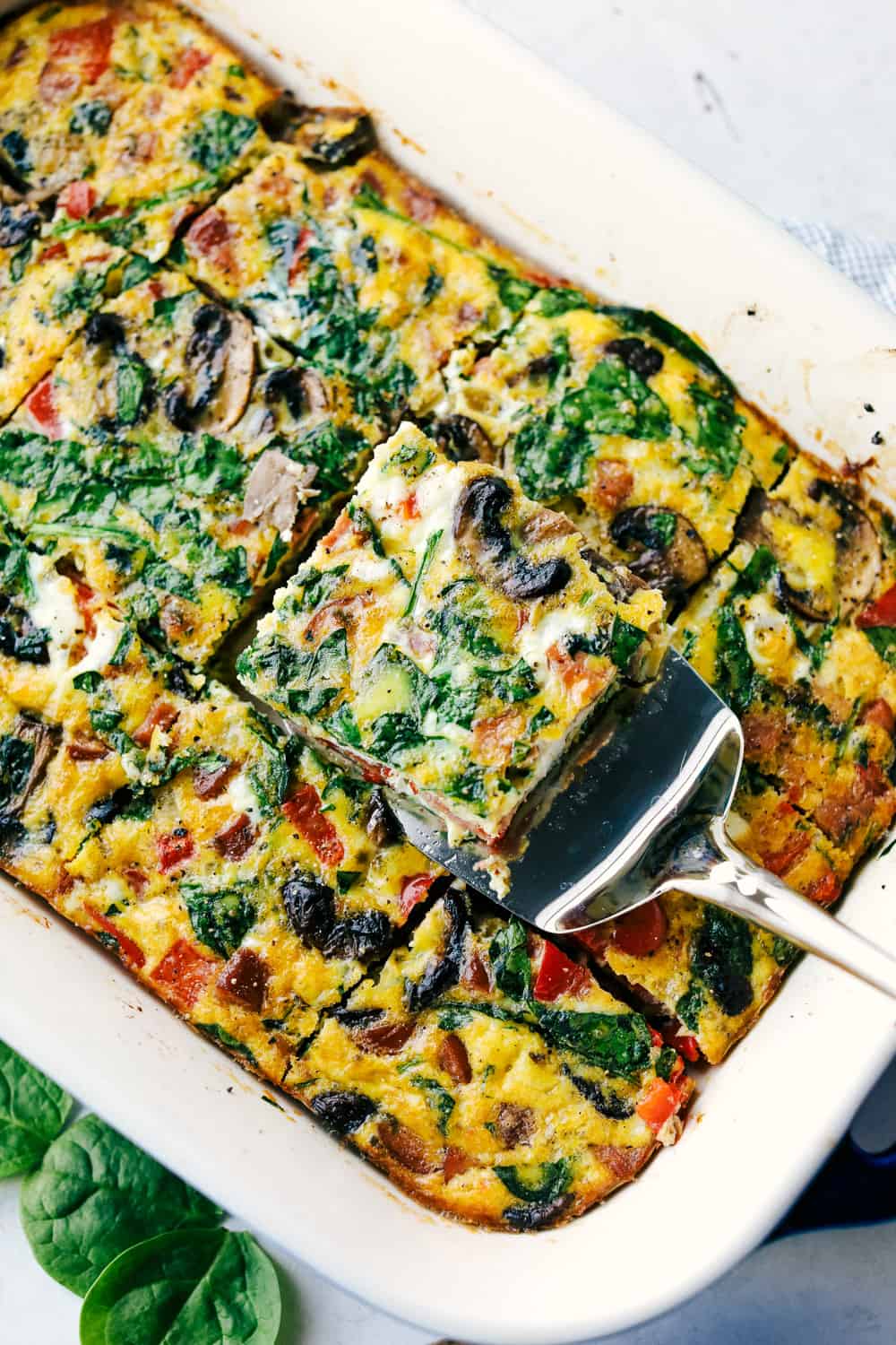 Sausage Mushroom Breakfast Bake is a blend ofย sautรฉed smoked sausage and fresh vegetables, added to a scrambled egg mixture then baked in less that 30 minutes. Thisย breakfast bake is perfect for theย holidays!ย Sausage mushroom breakfast bake sliced into pieces and ready to serve.