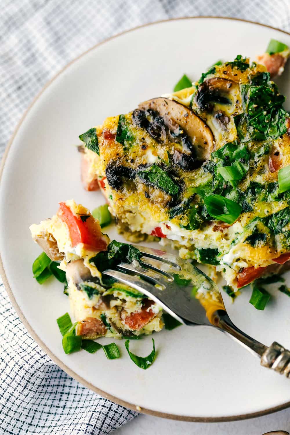 Sausage Mushroom Breakfast Bake is a blend ofย sautรฉed smoked sausage and fresh vegetables, added to a scrambled egg mixture then baked in less that 30 minutes. Thisย breakfast bake is perfect for theย holidays!ย Sausage mushroom breakfast bake served on a plate.
