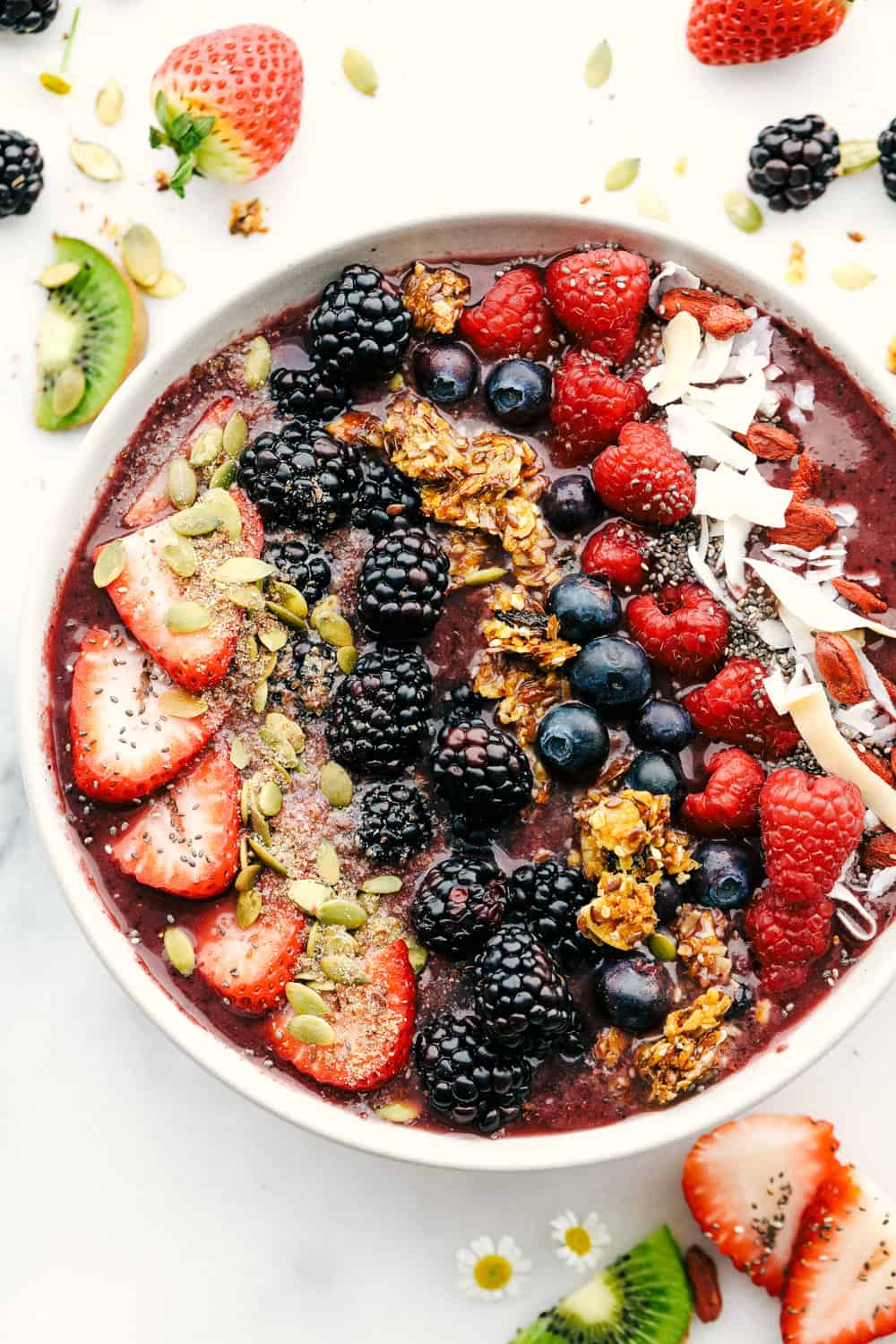 The Best Acai Bowls (Three Ways!) is a fruit filled bowl full of acai berries and juice topped with granola, fresh fruits, crunchy nuts and a variety of seeds all drizzled with a fun topping. A perfect way to start your day or keep it going! The very berry acai bowl with fruit and granola over top