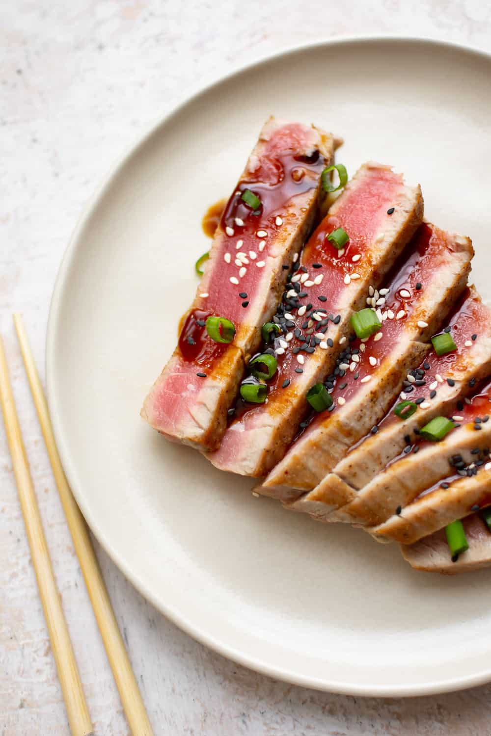 Ahi Tuna is a restaurant favorite that's easier to make at home than you think! It's quick and healthy - great for something a little different on a weeknight. seared ahi tuna cut up and plated