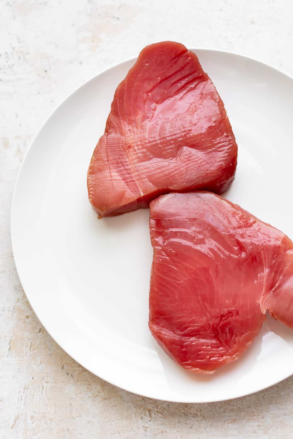 Ahi Tuna is a restaurant favorite that's easier to make at home than you think! It's quick and healthy - great for something a little different on a weeknight. raw ahi tuna steaks