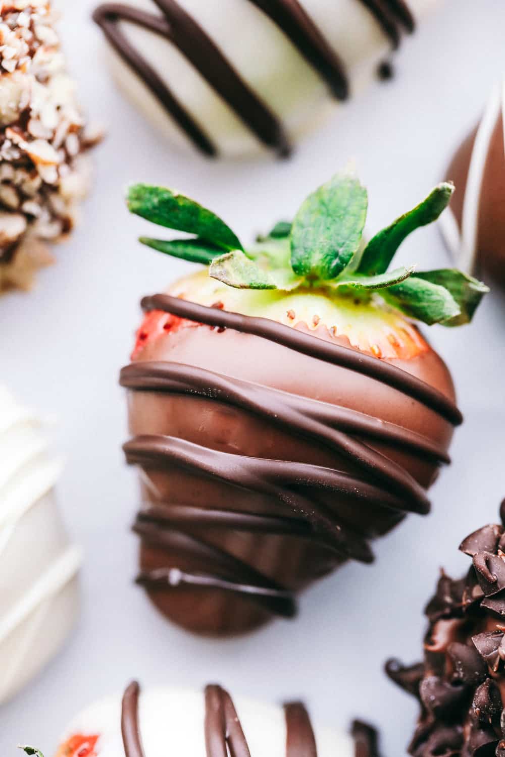 Chocolate-covered strawberries are ripe, juicy strawberries that are dipped it into melted chocolate. Then, you garnish them with a variety of toppings to really make this treat for just about everyone! Chocolate covered strawberry with chocolate drizzle over top.